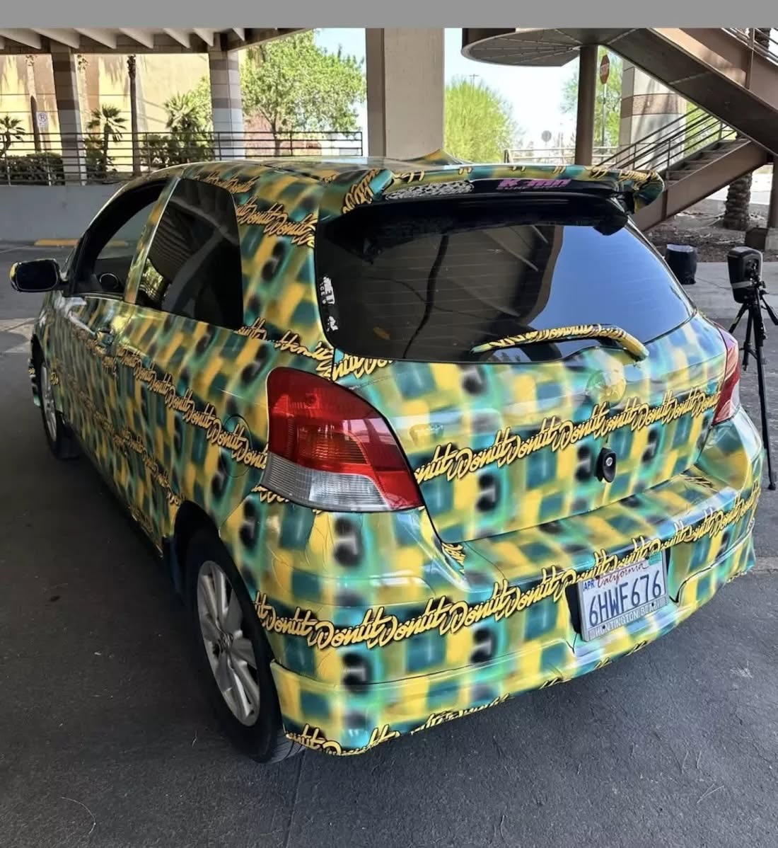 一輛車身貼滿綠黃相間特殊圖案的汽車